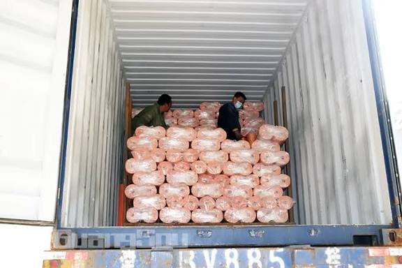 Wrapped mesh rolls stacked inside a shipping container